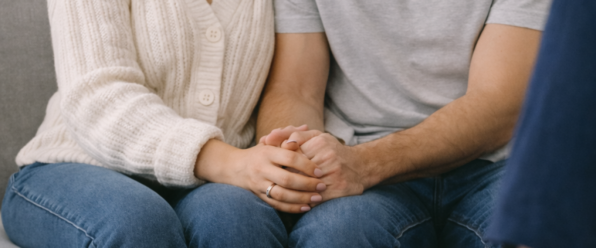 Couple sitting closely together during a pre-marital counselling session, engaging in a supportive discussion